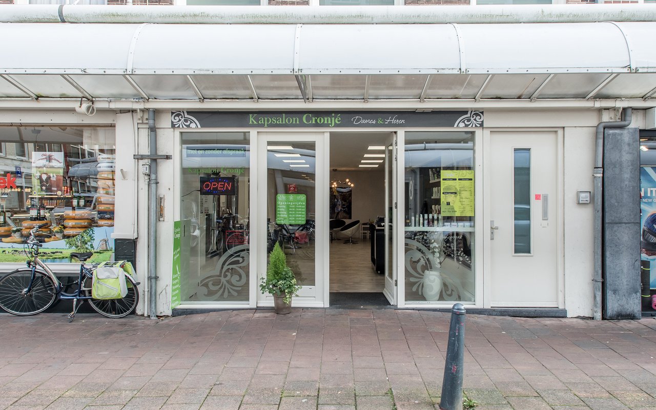 De winkelpui van Kapsalon Cronjé met het opschrift Dames & Heren, een open-bord en een fiets voor de deur